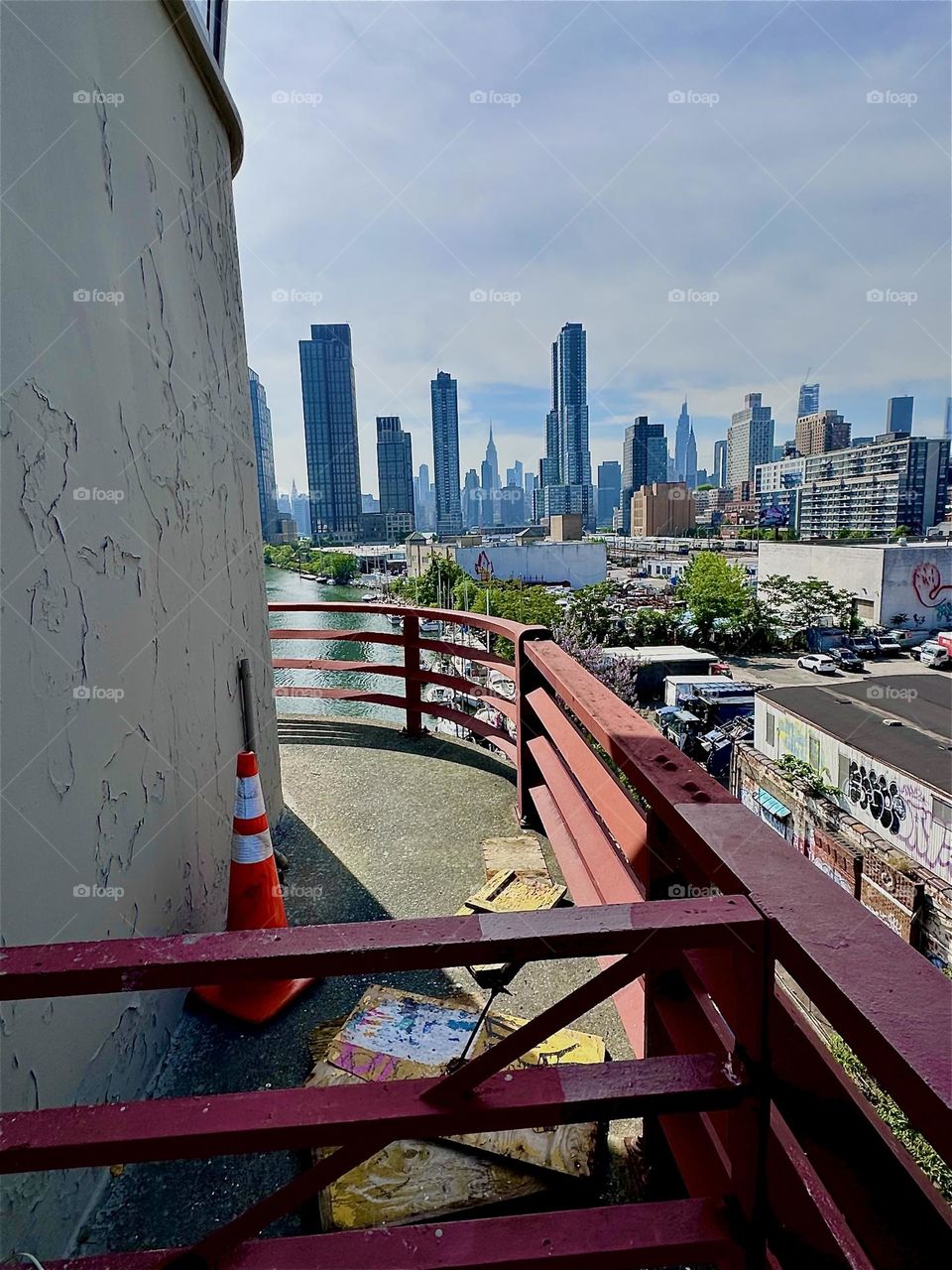 This is the center outpost of the “Pulaski Bridge” that connects LIC to “Greenpoint”, Bklyn overlooking “Newtown Creek”, an ocean inlet of the “East River”. Across the water we see “Manhattan” incl. the “Empire State Bldg”. 2024. Hypnotic Productions