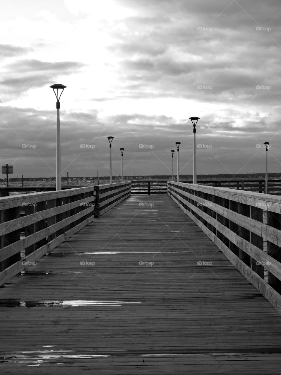 Landscapes of 2019 - Foap Missions - A black and white view of a fishing pier extending into the bay on a rainy and stormy day