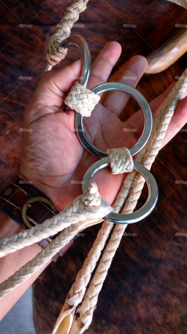 Em minha mão, um chicote (reio) de couro cru com argolas de inox. Artesanal de selaria. Pra chicotear (bater) em animais na lida do campo.