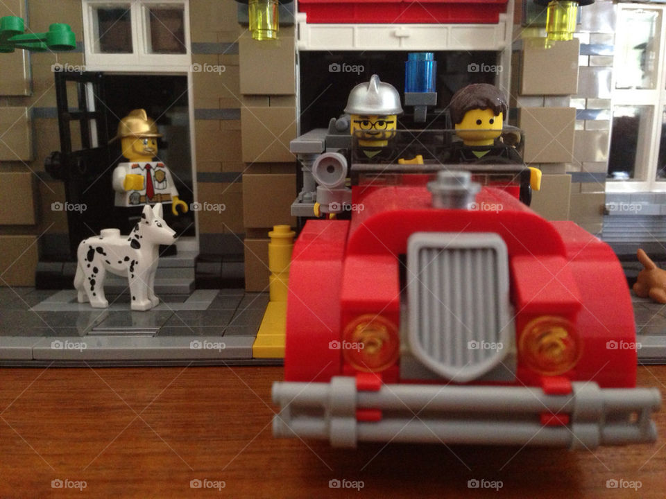 An old firetruck departs from firestation