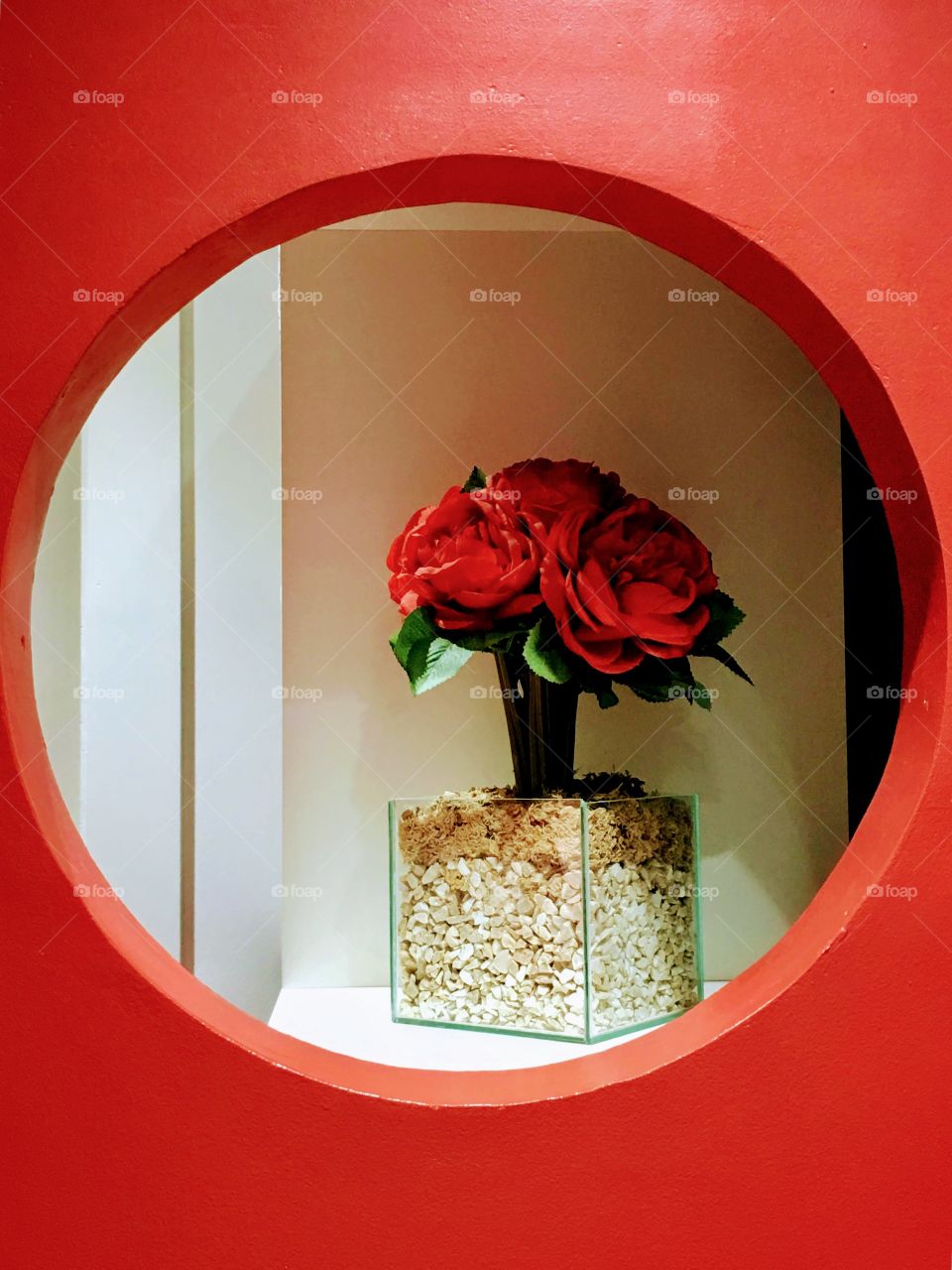 Red decorative flower on a circular shelf