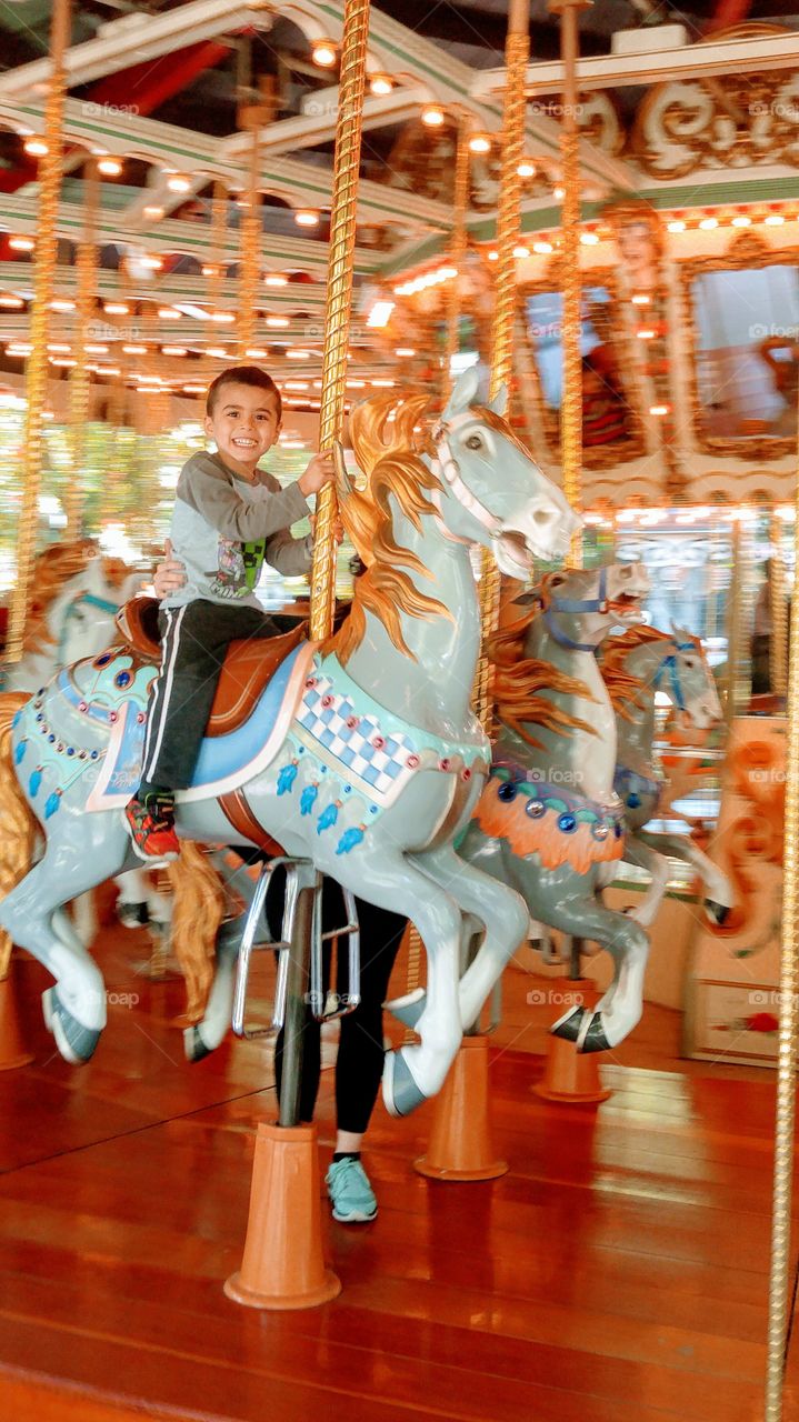 Cute boy enjoying ride in amusement park