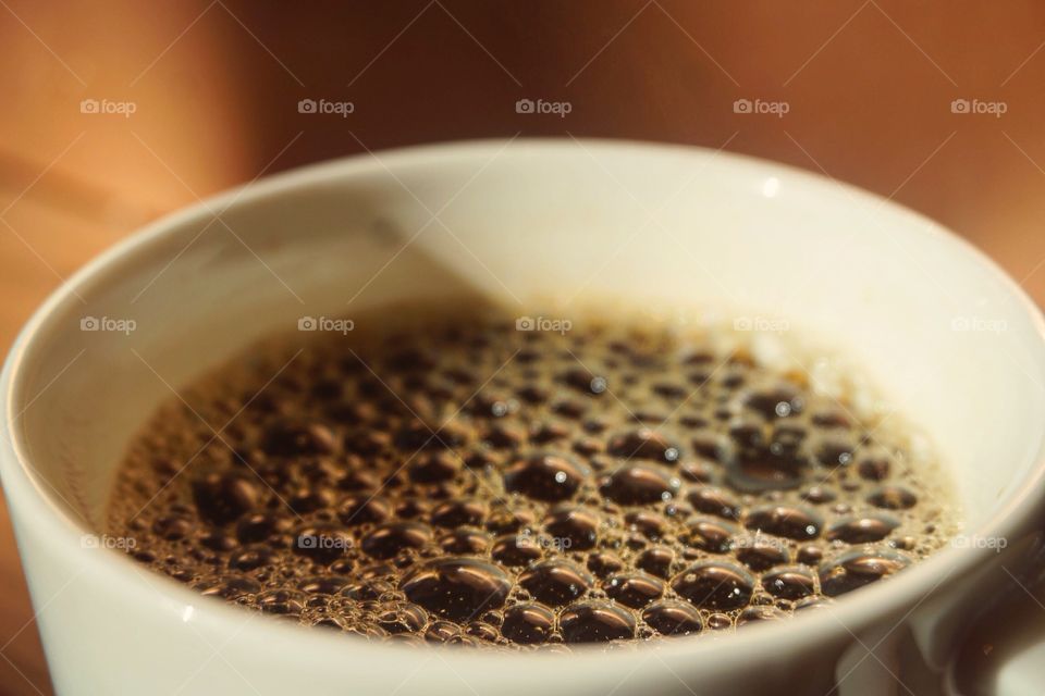 A closeup shot of a bubbly cup of coffee