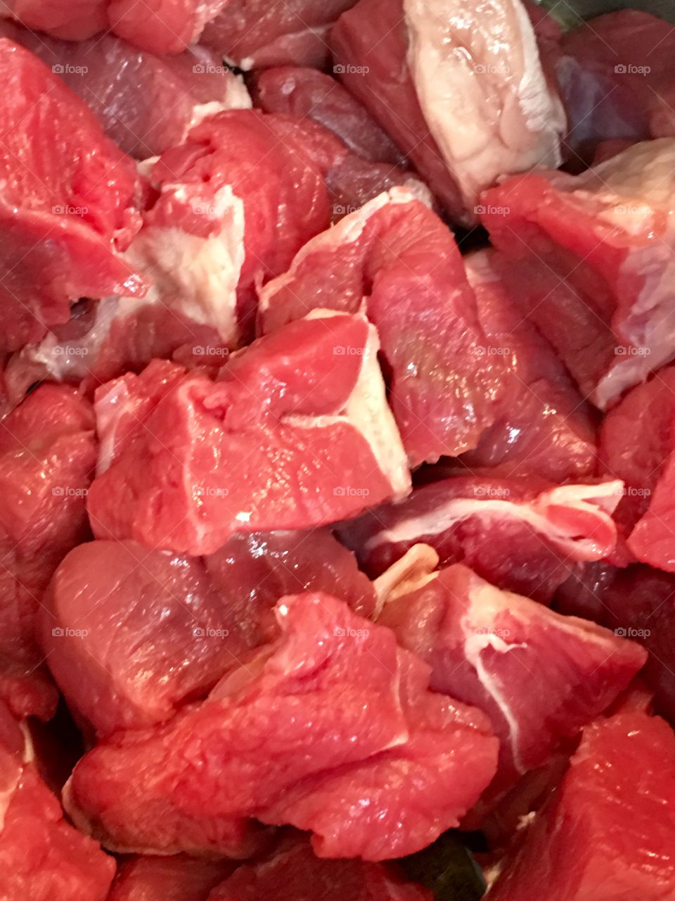 Chunks cubes of fresh raw beef in preparation for beef hot pot stew