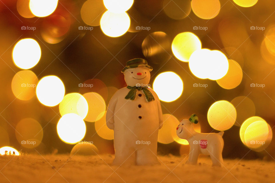 Snowman and dog with blurred Christmas lights
