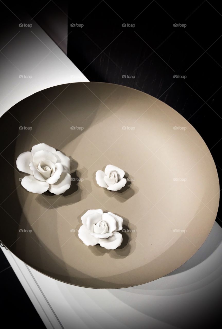 A bowl of three blooming white roses 