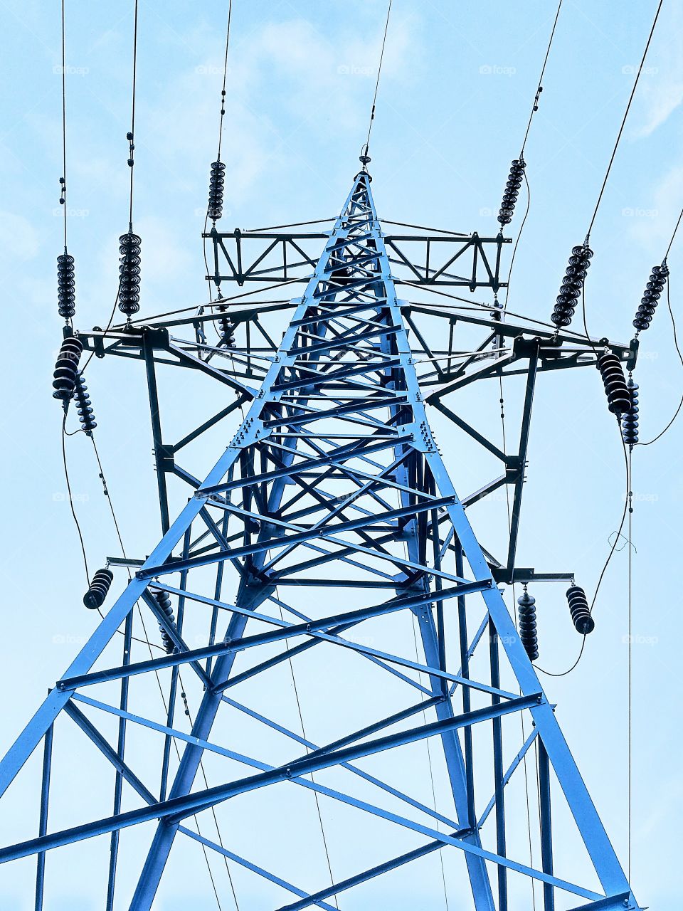 power line mast, metel construction,metalwork, electric insulatir, elrctrical wire,blue sky.