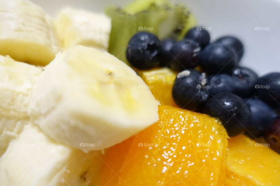 Close up fruit image : banana, orange, blueberries and kiwi.