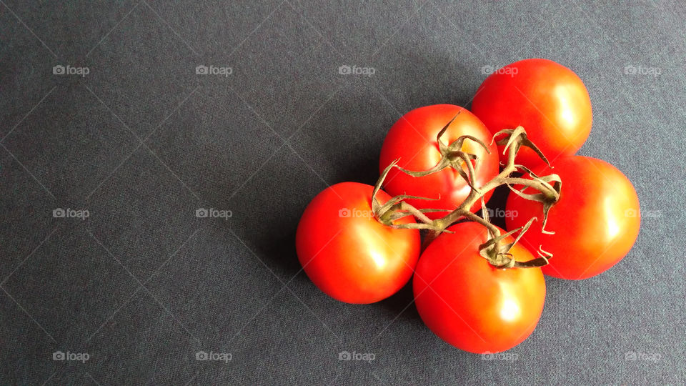 Ripe tomatoes on the grey background