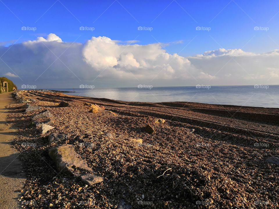 Sea with clouds and stones beach