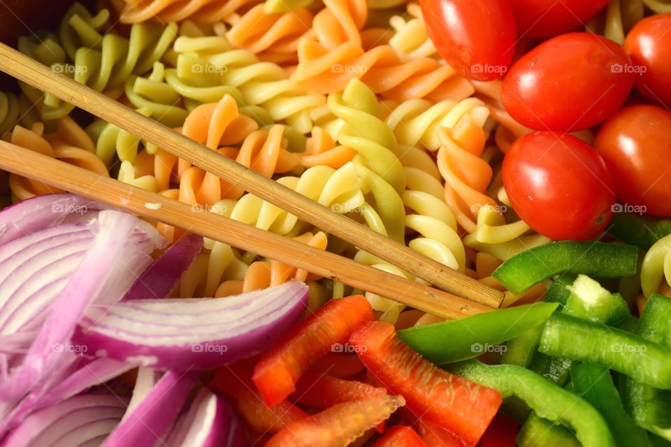 Closeup shot of padta salad with red pepper, green pepper and red onion.