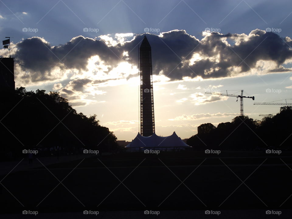 Washington Monument backlit by cloudy sky