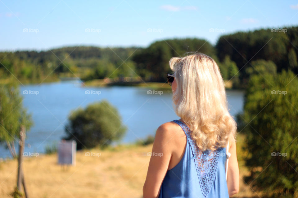 girl with blond hair is looking at the beautiful landscape