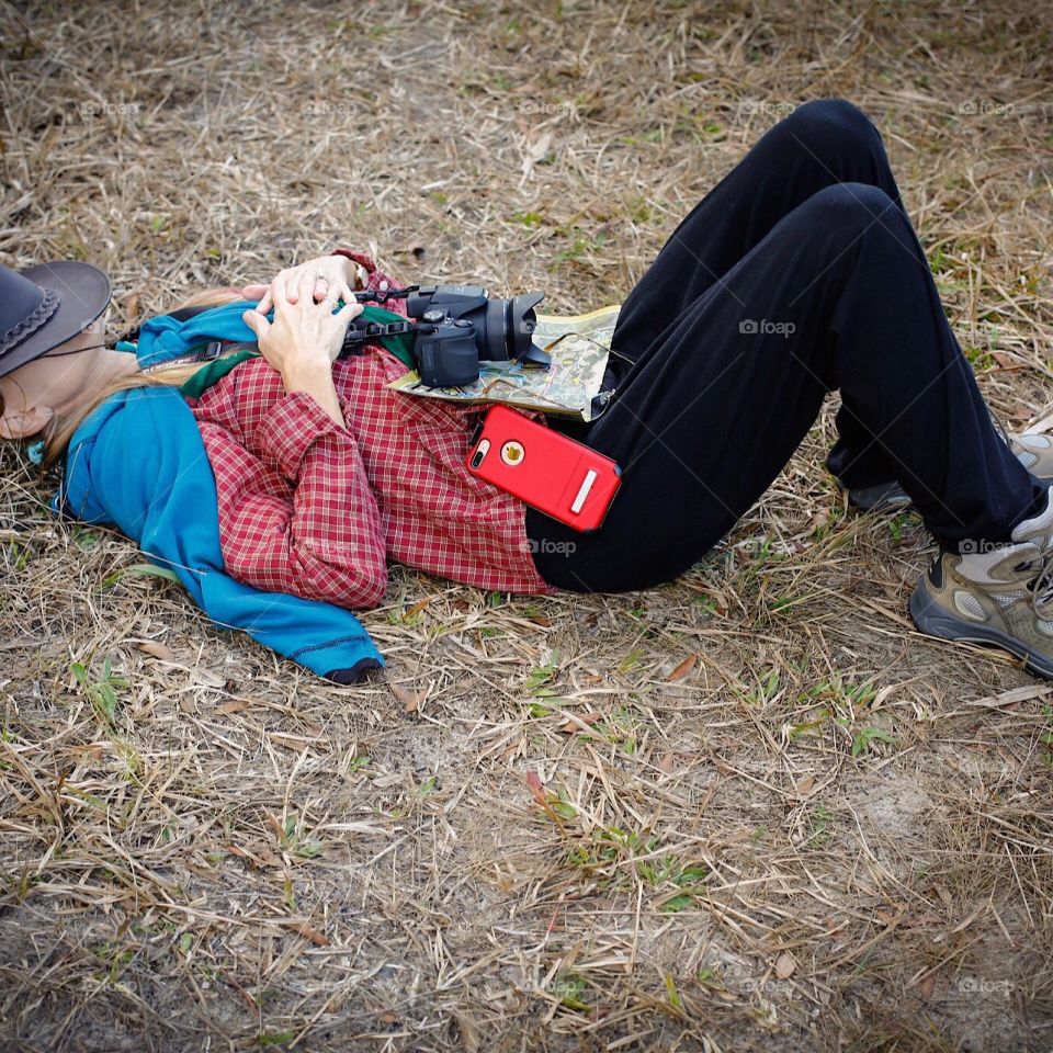 Woman taking a relaxing break before continuing on a long hike through the woods.