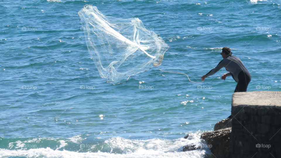 Fisherman throws the net into the sea to fish