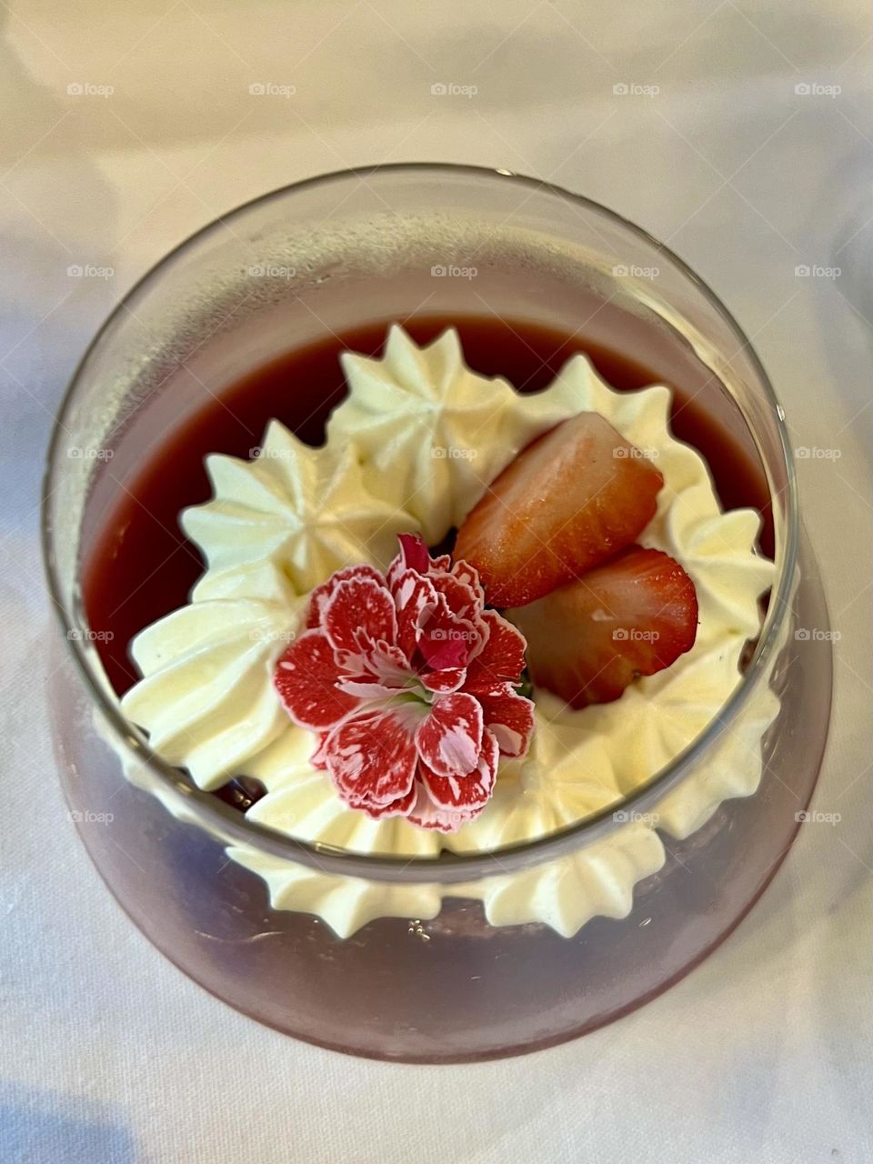 A flower floating on a bed of strawberries and cream is summer in a glass to me. 