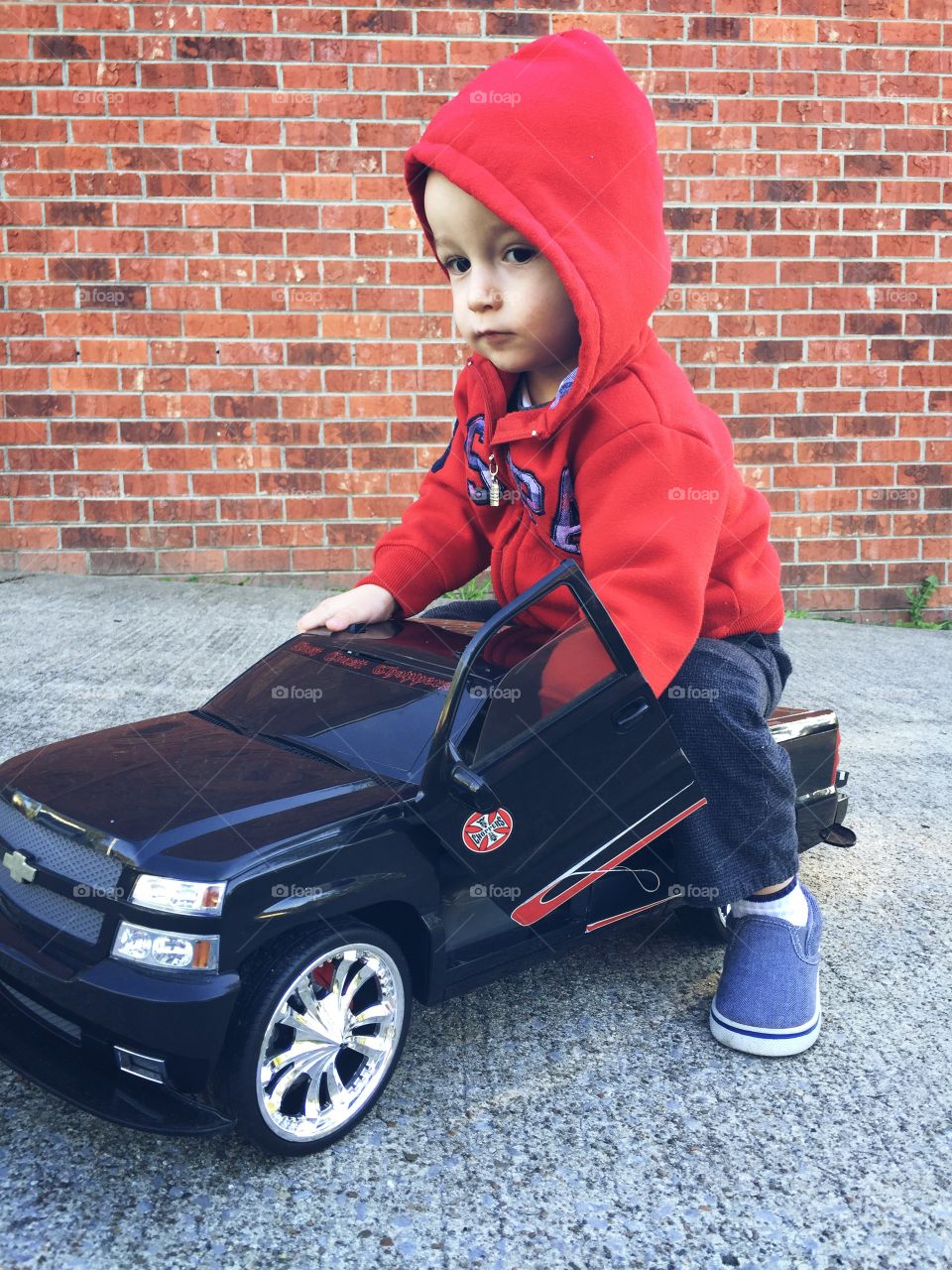 Baby sitting on small toy car