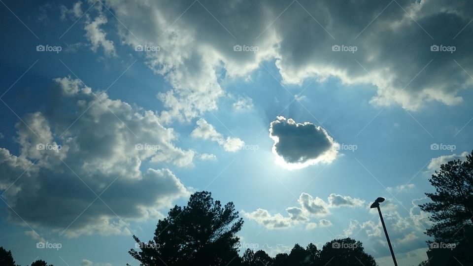 The sun shining through clouds