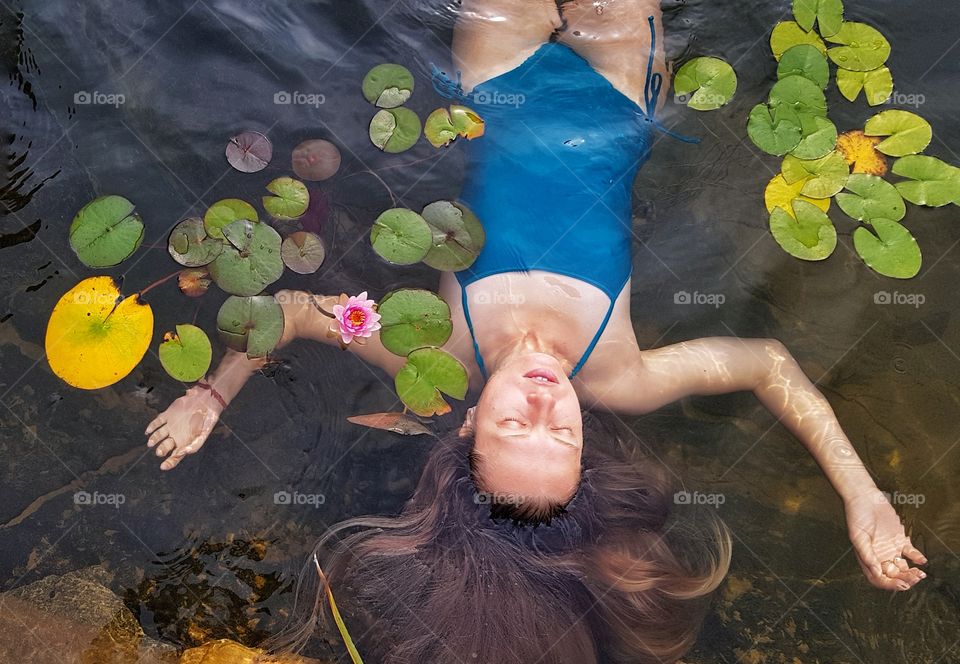 woman with long hair in the pond with waterlilies