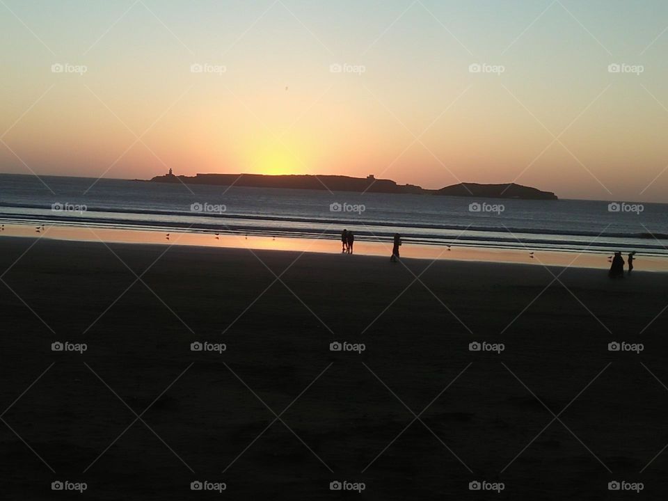 Beautiful sunset and some people around the beach at essaouira City in Morocco.