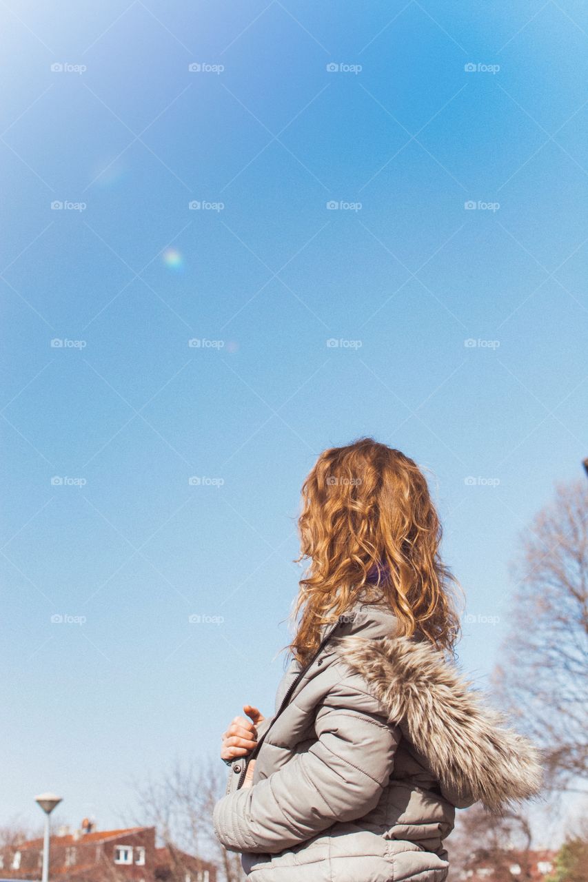 Blue skies and girl with the golden hair. Waiting patiently for spring to arrive.