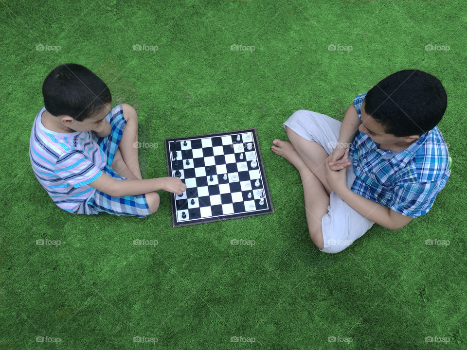 my sons playing in chess in the backyard