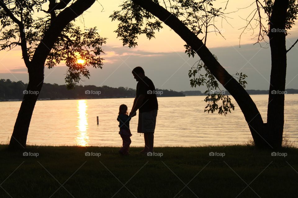The silhouette of father and daughter holding hands during the evening hour right before sunset makes this photo so special! 