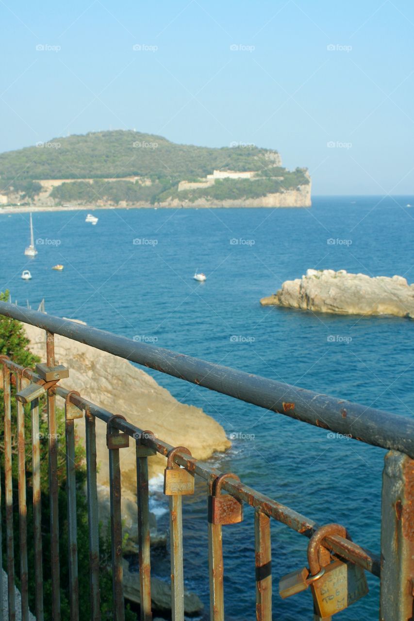 Padloks on railing, seascape in background