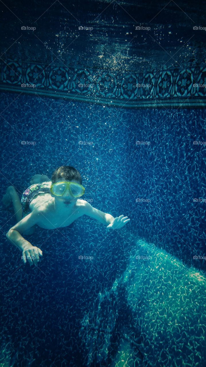 Boy swimming in the pool with mask