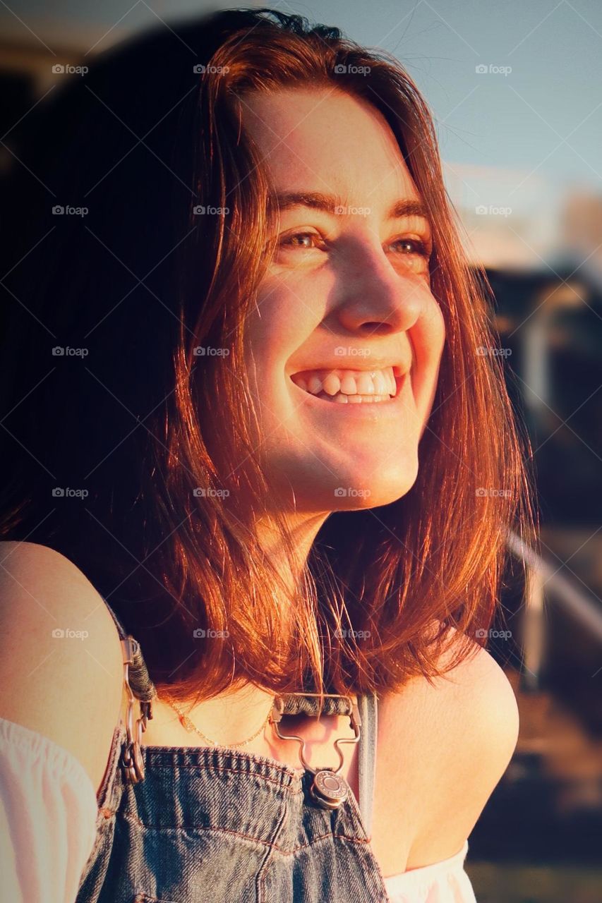 Healthy young woman exudes confidence and joy in the glow of a summer sunset 