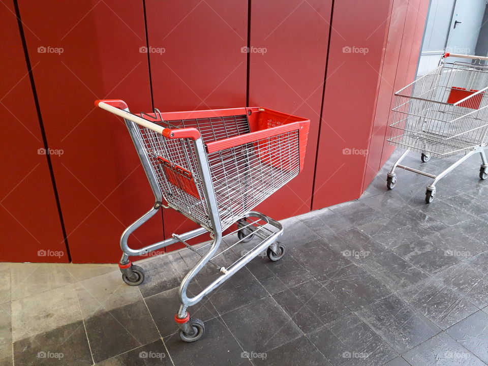 Carts for grocery products stand near a supermarket on the street