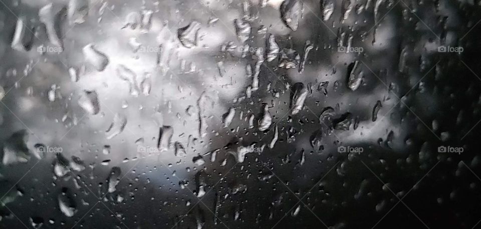 looking out the window of a truck on a rainy day at a camp site.