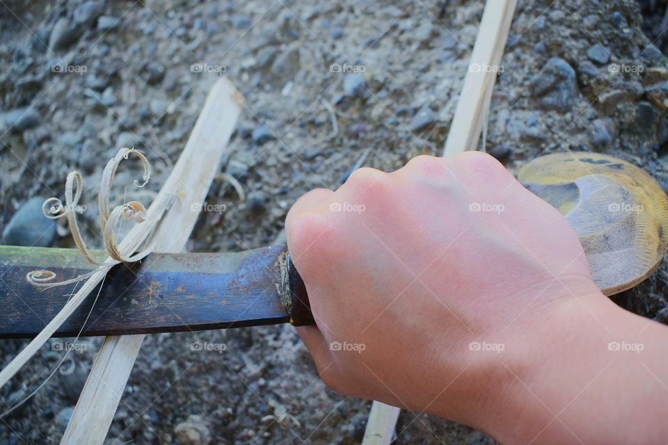 Close-up of a person splitting bamboo strips