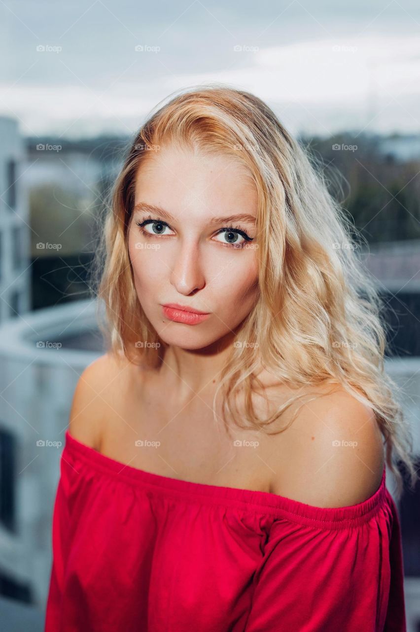 Portrait of young female with blonde hair, wearing a pink shoulderless top