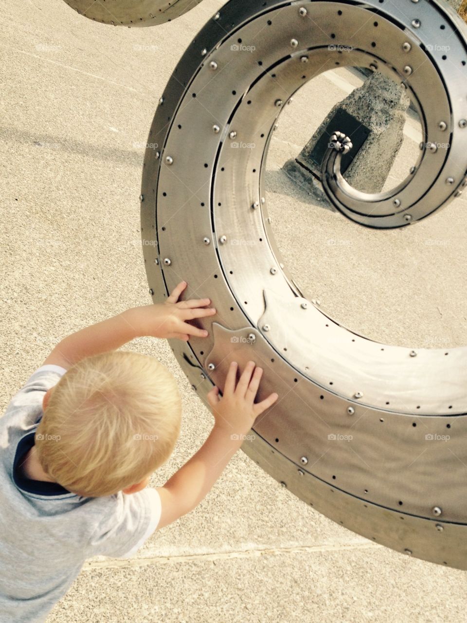 Wish Upon A Star. A little boy reaches for the star in the middle of a sculpture at Hiram Chittenden Locks.