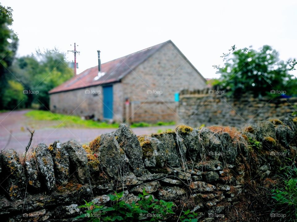 A wide aperture shot of an old barn in rural England. These fantastic stone walls are everywhere.