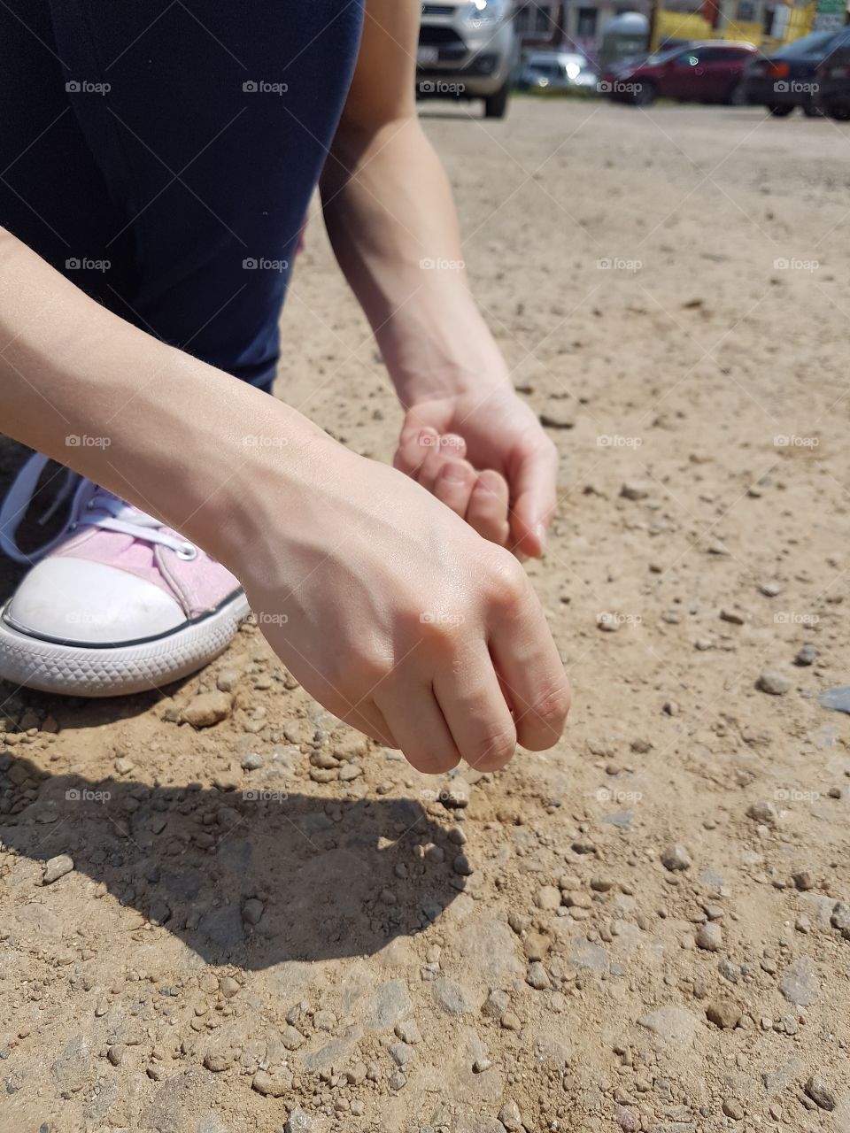 kids hand with little stones