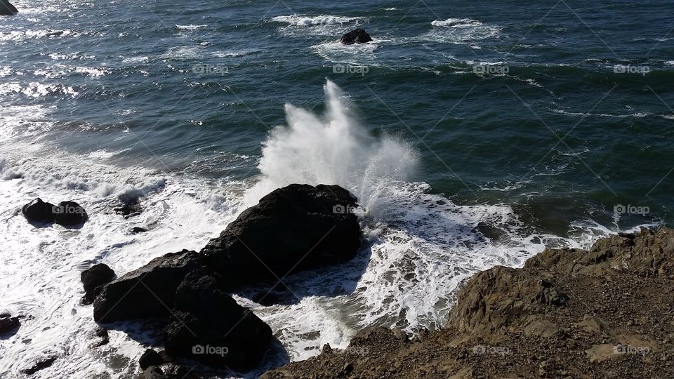 Beautiful beach crashing waves. Turbulent waters, crashing waves and rocky beach