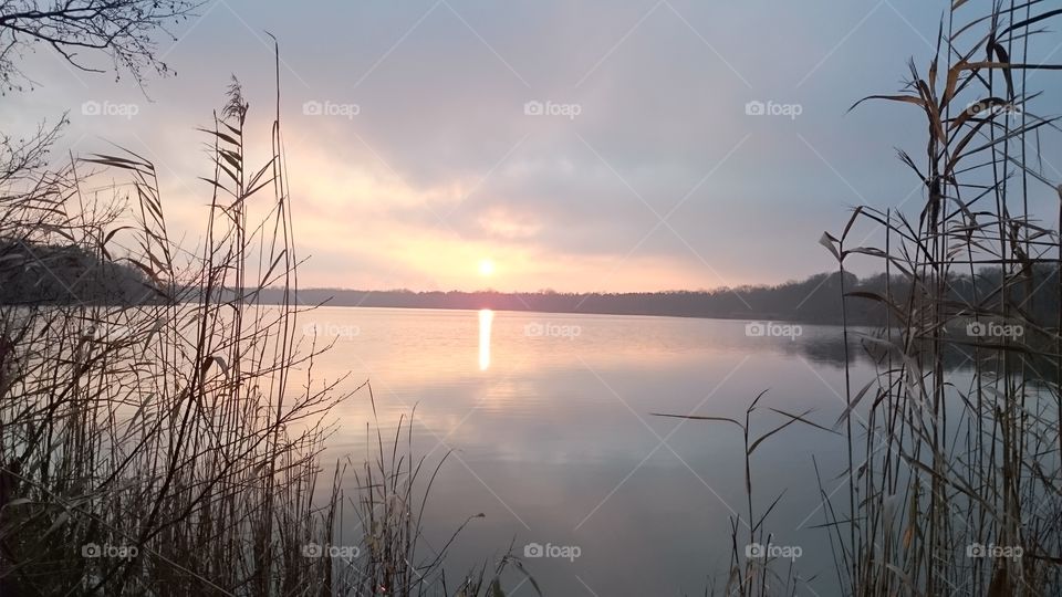 Sunset with reflecting sun and sky in the lake