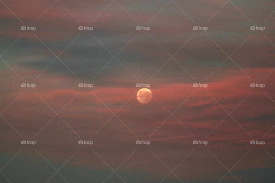 pink clouds over moon at daw