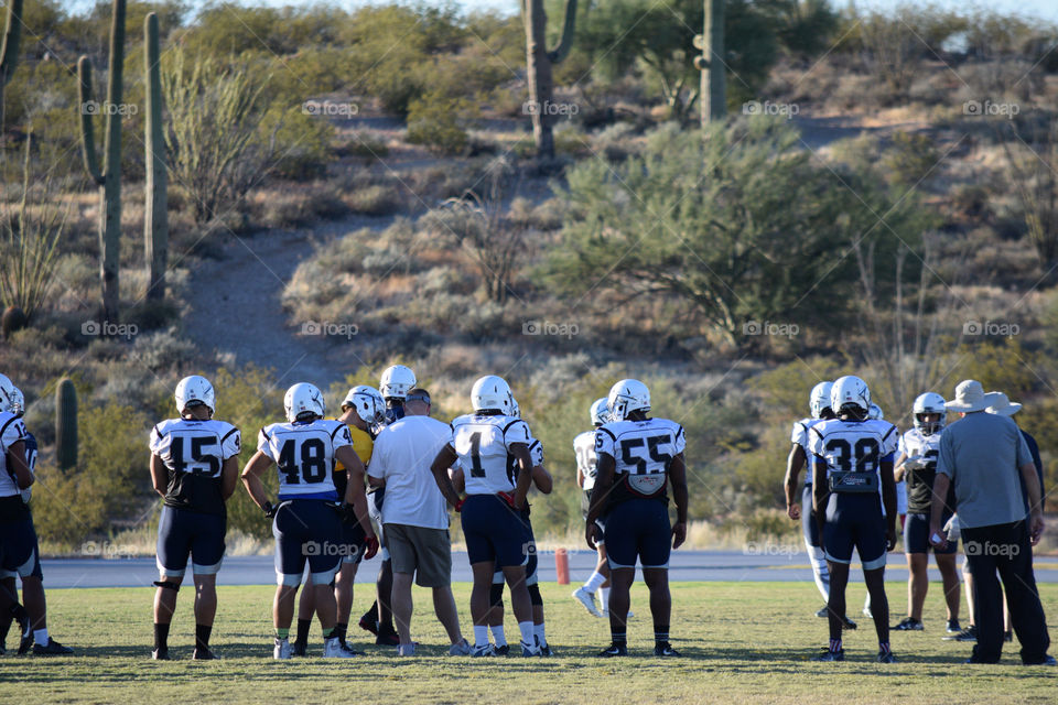 Football players practice with their coaches