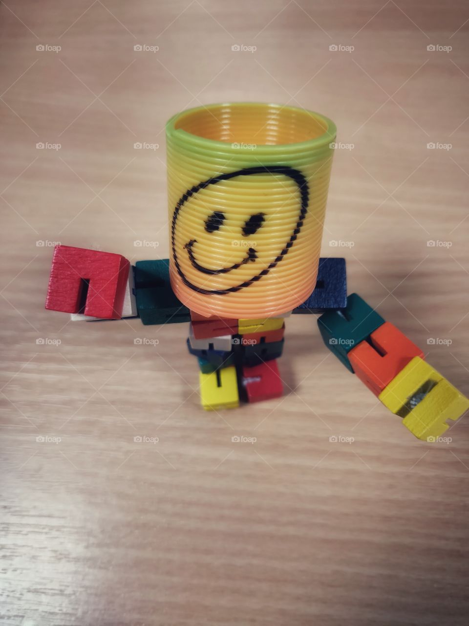 Smiley emoji man on the office desk by the laptop and keyboard