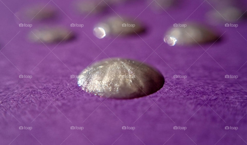 Silver drop on purple paper