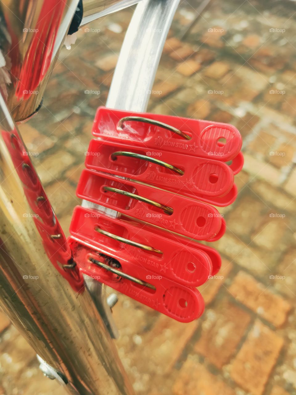clothespins that were red in the afternoon sun. attached to a stainless coat hanger