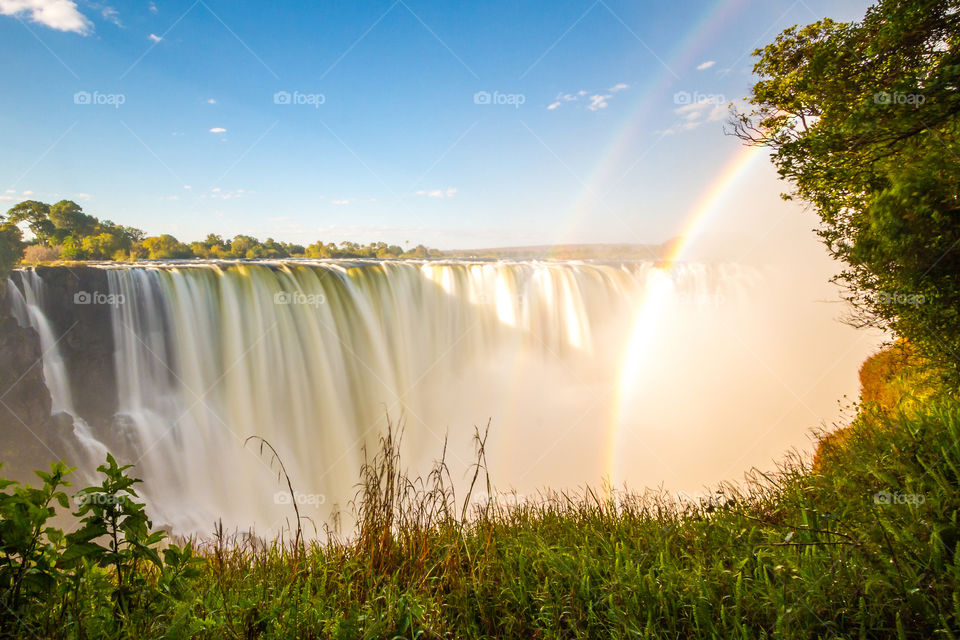 Majestic waterfall with slow shutter and double rainbow seen through the mist. Such a scenic view - 2019 memories