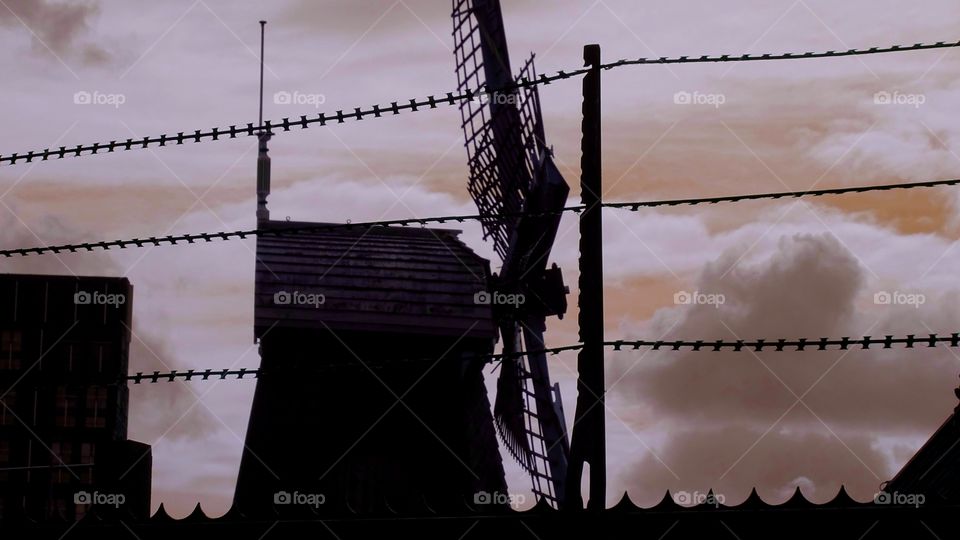 An historical Netherlandes' windmill found in the centre of Amsterdam on a sunset background.