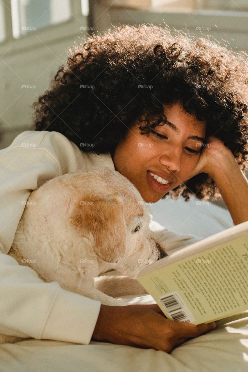Dog is reading book with her owner
