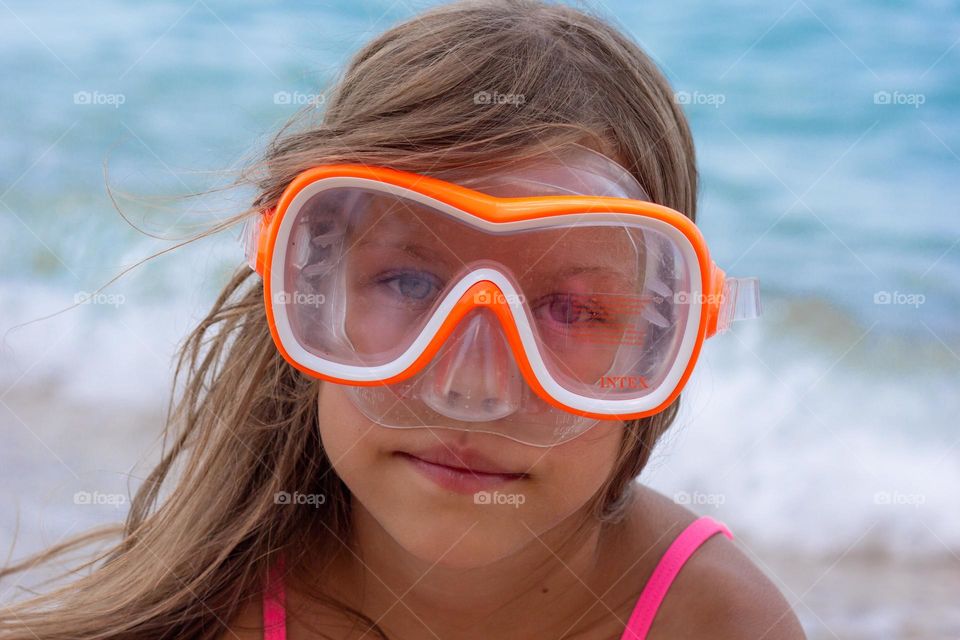 Portrait of caucasian child of 7-8 years in swimming mask looking at camera