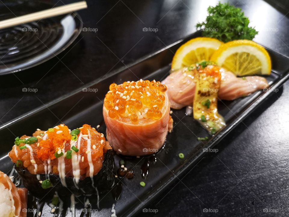 Many Types of Sushi on Black plate. Japanese Food