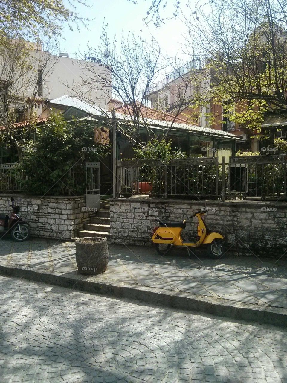 Traditional cafe in Giannena, Greece. Parked outside is a yellow moped